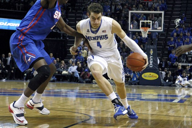 Memphis' Austin Nichols (4) powers past SMU's Yanick Moreira (2) in the first half of an NCAA college basketball game Thursday, Feb. 26, 2015, in Memphis, Tenn. (AP Photo/Karen Pulfer Focht)