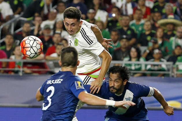 Mexico midfielder Hector Herrera, top left, gets off a header in front of Guatemala forward Carlos Ruiz, right, as Guatemala defender Elias Enoc Vasquez (3) moves in to cut the ball off during the second half of a CONCACAF Gold Cup soccer match Sunday, July 12, 2015, in Glendale, Ariz.  The game ended in a 0-0 tie. (AP Photo/Ross D. Franklin)