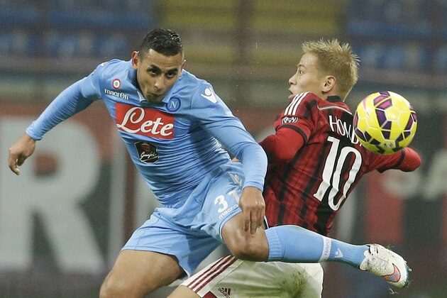 AC Milan's Keisuke Honda, right, jumps for the ball with Napoli’s Faouzi Ghoulam during a Serie A soccer match between AC Milan and Napoli at the San Siro stadium in Milan, Italy, Sunday, Dec. 14, 2014. (AP Photo/Antonio Calanni)