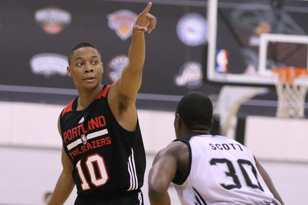 Portland Trail Blazers' Tim Frazier,  left, calls a playas he is guarded by San Antonio Spurs' Shannon Scott during the first half of an NBA summer league basketball game Tuesday, July 14, 2015,  in Las Vegas. (AP Photo/Ronda Churchill)
