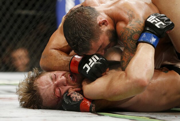 Chad Mendes elbows Conor McGregor during their interim featherweight title mixed martial arts bout at UFC 189 on Saturday, July 11, 2015, in Las Vegas. (AP Photo/John Locher)