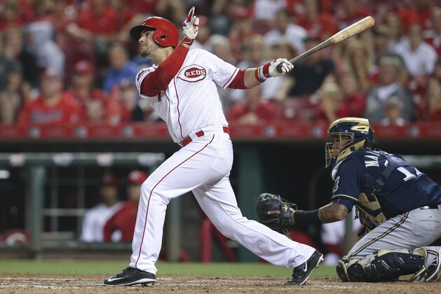 Cincinnati Reds' Eugenio Suarez hits a single to drive home Jay Bruce during the ninth inning of a baseball game against the Milwaukee Brewers, Friday, July 3, 2015, in Cincinnati. The Brewers won 12-1. (AP Photo/John Minchillo)