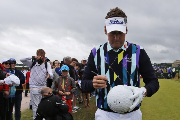 England’s Ian Poulter signs an autograph on a giant golf ball replica as he walks off the fourth tee during a practice round at the British Open Golf Championship at the Old Course, St. Andrews, Scotland, Tuesday, July 14, 2015. (AP Photo/Jon Super)