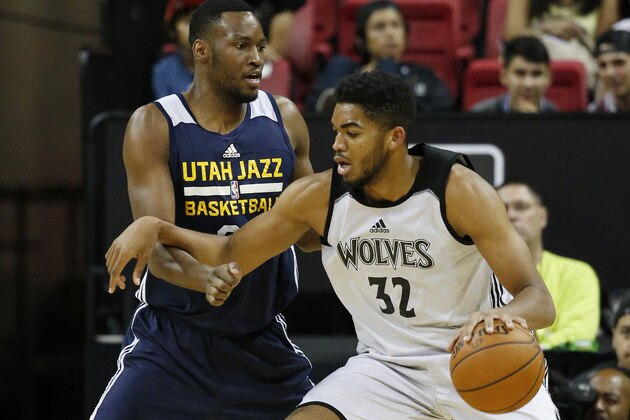 Minnesota Timberwolves’ Karl-Anthony Towns, right, drives into Utah Jazz’s JaJuan Johnson during the first half of an NBA summer league basketball game Monday, July 13, 2015, in Las Vegas. (AP Photo/John Locher)