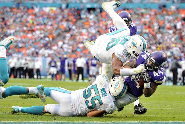 Dec 21, 2014; Miami Gardens, FL, USA; Minnesota Vikings running back Matt Asiata (44) dives into the end zone for a touchdown as Miami Dolphins outside linebacker Koa Misi (55) and defensive end Olivier Vernon (50) tackle him  in the second half of the game at Sun Life Stadium. Mandatory Credit: Brad Barr-USA TODAY Sports