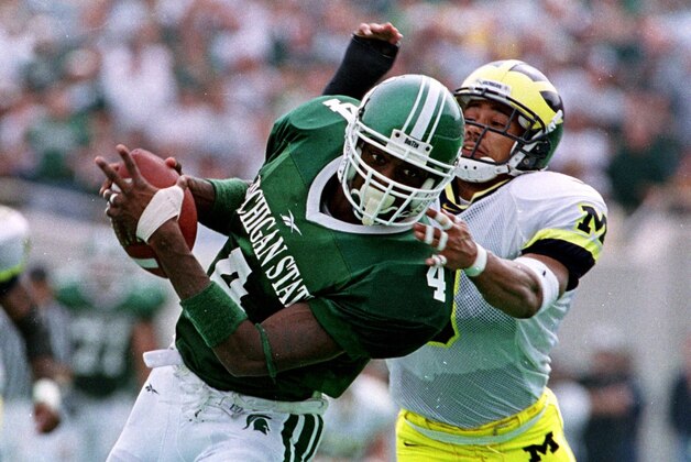Michigan State University receiver Plaxico Burress (4) pulls in a pass defended by University of Michigan cornerback Todd Howard during the second quarter at Spartan Stadium in East Lansing, Mich., Saturday, Oct. 9, 1999. Michigan State defeated Michigan 34-31.  Burress had 10 receptions for 255 yards, breaking the old school mark of 252 by Andre Rison in the 1989 Gator Bowl game against Georgia.(AP Photo/Werner Slocum)
