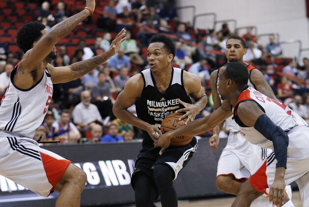 Milwaukee Bucks’ Rashad Vaughn drives between Houston Rockets’ DJ Kennedy, left, and Will Cummings, right, during the second half of an NBA summer league basketball game Wednesday, July 15, 2015, in Las Vegas. (AP Photo/John Locher)