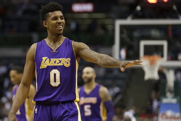Los Angeles Lakers' Nick Young gestures to a fan during an NBA basketball game against the Milwaukee Bucks Wednesday, Feb. 4, 2015, in Milwaukee. (AP Photo/Aaron Gash)