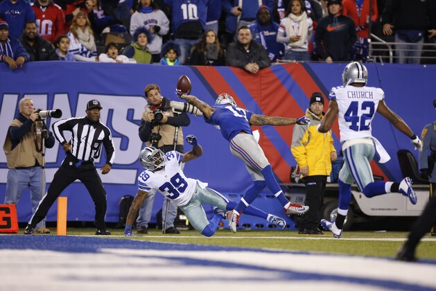 New York Giants wide receiver Odell Beckham Jr. (13) makes a one-handed catch for a touchdown against Dallas Cowboys cornerback Brandon Carr (39) in the second quarter of an NFL football game, Sunday, Nov. 23, 2014, in East Rutherford, N.J.  (AP Photo/Kathy Willens)
