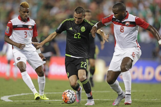 Mexico’s Paul Aguilar (22) drives between Trinidad & Tobago’s Khaleem Hyland (8)  and Joevin Jones (3) during the first half of a CONCACAF Gold Cup soccer match in Charlotte, N.C., Wednesday, July 15, 2015. (AP Photo/Gerry Broome)