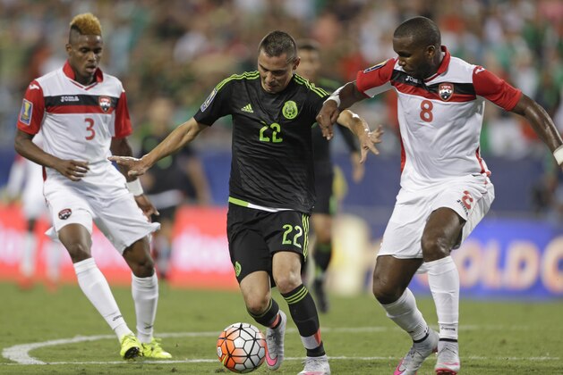 Mexico’s Paul Aguilar (22) drives between Trinidad & Tobago’s Khaleem Hyland (8)  and Joevin Jones (3) during the first half of a CONCACAF Gold Cup soccer match in Charlotte, N.C., Wednesday, July 15, 2015. (AP Photo/Gerry Broome)