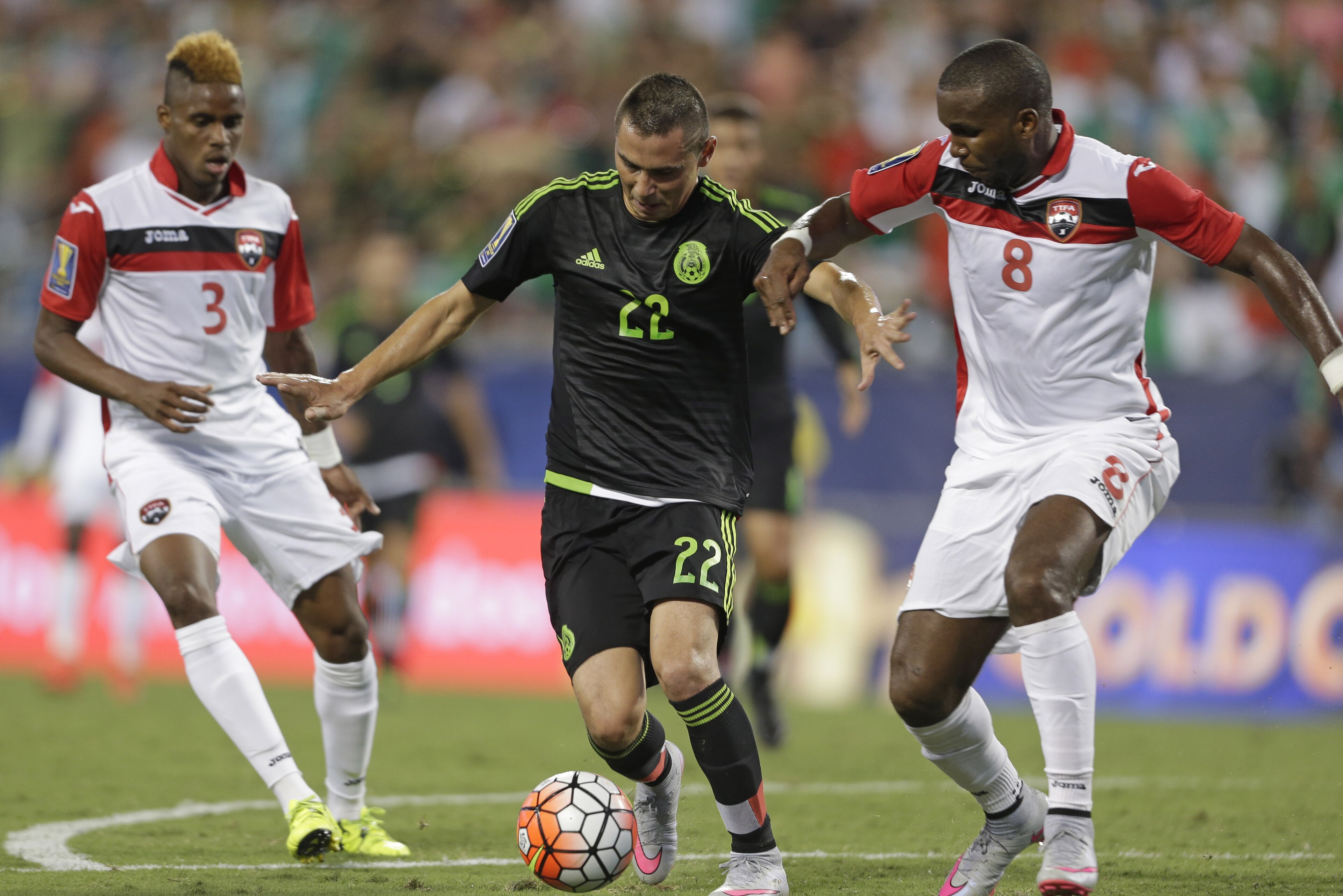 Mexico’s Paul Aguilar (22) drives between Trinidad & Tobago’s Khaleem Hyland (8)  and Joevin Jones (3) during the first half of a CONCACAF Gold Cup soccer match in Charlotte, N.C., Wednesday, July 15, 2015. (AP Photo/Gerry Broome)