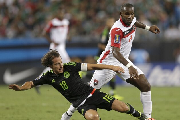 Mexico’s Andres Guardado (18) knocks the ball from Trinidad & Tobago’s Khaleem Hyland (8) during the first half of a CONCACAF Gold Cup soccer match in Charlotte, N.C., Wednesday, July 15, 2015. (AP Photo/Chuck Burton)