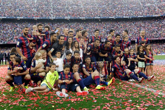 FC Barcelona players pose with their trophy after winning the Spanish League title, at the end of their Spanish La Liga last round soccer match against Deportivo Coruna at the Camp Nou stadium in Barcelona, Spain, Saturday, May 23, 2015. (AP Photo/Manu Fernandez)