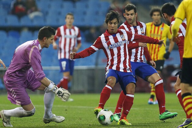 Sant Andreu's goalkeeper Pau Nunez, left, in action with Atletico's Oliver Torres, centre during a Copa del Rey soccer match between Atletico de Madrid and Sant Andreu at the Vicente Calderon stadium in Madrid, Spain, Wednesday, Dec. 18, 2013. (AP Photo/Andres Kudacki)