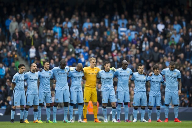 Manchester City players line up for a minutes silence to remember the victims of the Bradford fire before the English Premier League soccer match between Manchester City and Aston Villa at the Etihad Stadium, Manchester, England, Saturday April 25, 2015. (AP Photo/Jon Super)