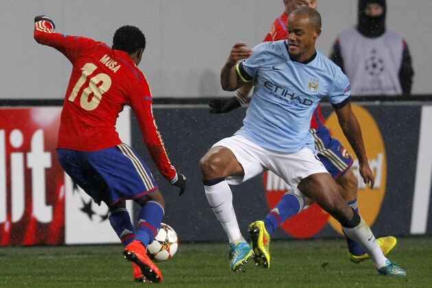 CSKA's Ahmed Musa, left, and Manchester City's Vincent Kompany, right, challenge for the ball during the Group E Champions League soccer match between CSKA Moscow and Manchester City at Arena Khimki stadium in Moscow, Russia, Tuesday, Oct. 21, 2014. (AP Photo/Pavel Golovkin)