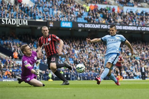 Manchester City's Sergio Aguero, right, scores past Queens Park Rangers' goalkeeper Robert Green during the English Premier League soccer match between Manchester City and Queens Park Rangers at the Etihad Stadium, Manchester, England, Sunday May 10, 2015. (AP Photo/Jon Super)
