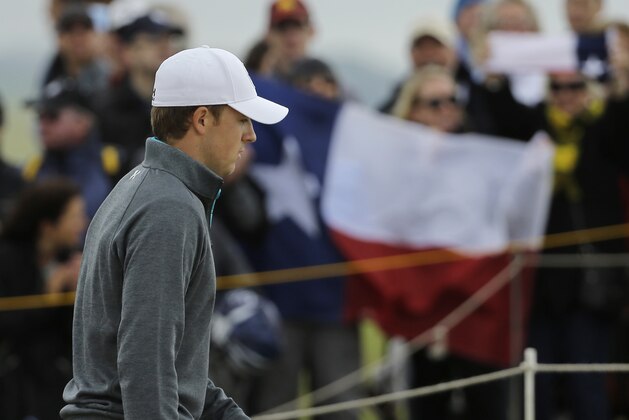 United States’ Jordan Spieth walks past a spectator holding the flag of Texas on the 13th hole during the first round of the British Open Golf Championship at the Old Course, St. Andrews, Scotland, Thursday, July 16, 2015. (AP Photo/David J. Phillip)