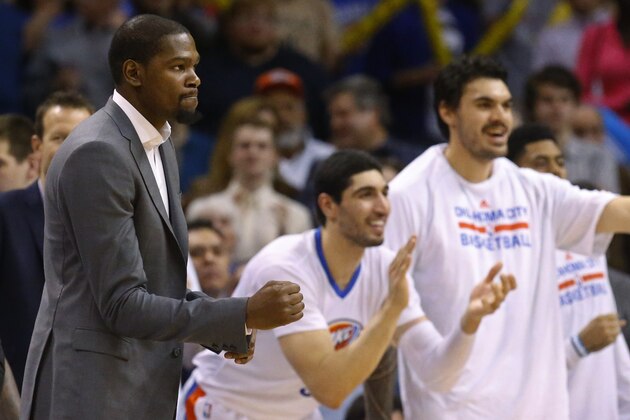 Injured Oklahoma City Thunder forward Kevin Durant, left, pumps his fist at teammates Enes Kanter, center, and Steven Adams, right, cheer in the fourth quarter of an NBA basketball game against the Toronto Raptors, Sunday, March 8, 2015, in Oklahoma City. Oklahoma City won 108-104. (AP Photo/Sue Ogrocki)