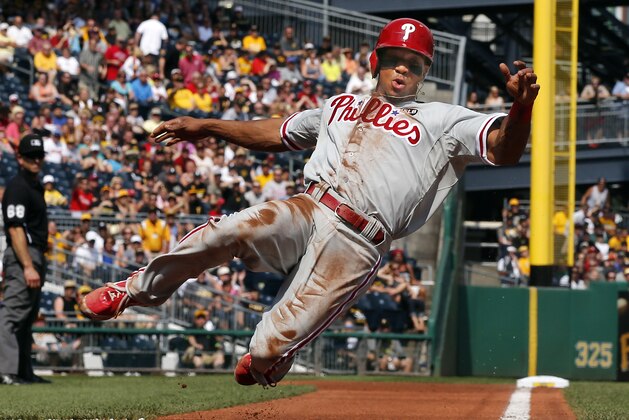 Philadelphia Phillies' Ben Revere scores from third on an infield ground out by Chase Utley in the first inning of a baseball game in Pittsburgh, Saturday, June 13, 2015. (AP Photo/Gene J. Puskar)