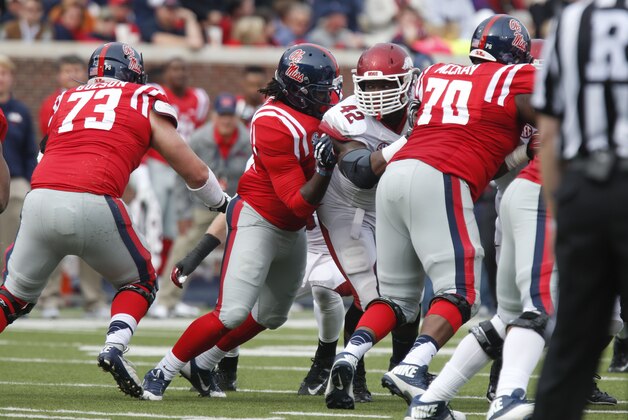 Arkansas defensive end Chris Smith (42) tries to fight his way past Mississippi offensive linesman Emmanuel McCray (70) as teammate offensive linesman Austin Golson (73) steps up to help block during the second half of their NCAA college football game at Vaught-Hemingway Stadium in Oxford, Miss., on Saturday, Nov. 9, 2013. Mississippi won 34-24. (AP Photo/Rogelio V. Solis)