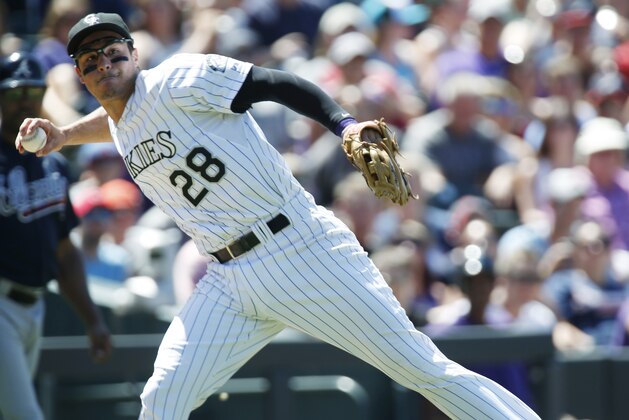 Colorado Rockies third baseman Nolan Arenado throws to first base to put out Atlanta Braves' Jace Peterson in the third inning of a baseball game Sunday, July 12, 2015, in Denver. (AP Photo/David Zalubowski)