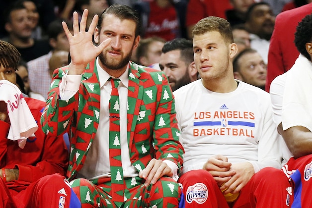 Los Angeles Clippers' Spencer Hawes, left, waves to the crowd wearing a Christmas themed suit next to Blake Griffin during the first half of an NBA basketball game against the Golden State Warriors, Thursday, Dec. 25, 2014, in Los Angeles. (AP Photo/Danny Moloshok)