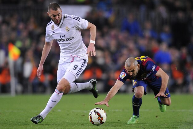 Real Madrid's Karim Benzema, left, takes the ball past Barcelona's Javier Mascherano during a Spanish La Liga soccer match between FC Barcelona and Real Madrid at Camp Nou stadium, in Barcelona, Spain, Sunday, March 22, 2015. (AP Photo/Manu Fernandez)
