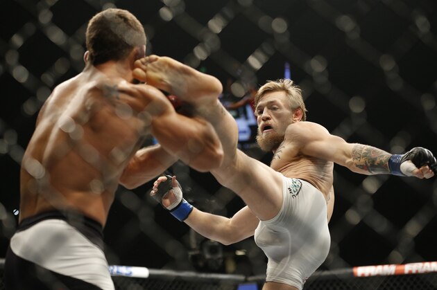 Conor McGregor, right, kicks Chad Mendes during their interim featherweight title mixed martial arts bout at UFC 189 Saturday, July 11, 2015, in Las Vegas. (AP Photo/John Locher)