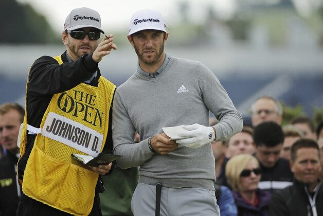 United States’ Dustin Johnson, right, speaks with his caddie Austin Johnson during the first round of the British Open Golf Championship at the Old Course, St. Andrews, Scotland, Thursday, July 16, 2015. (AP Photo/David J. Phillip)