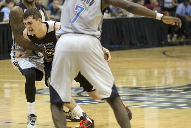 Orlando Magic's Mario Hezonja (23) center, charges through the tough Oklahoma City Thunder defenders Levi Randolph (31) left and Semaj Christon (7) right during the second half of an NBA summer league basketball game in Orlando, Fla., Monday, July 6, 2015. (AP Photo/Willie J. Allen Jr.)