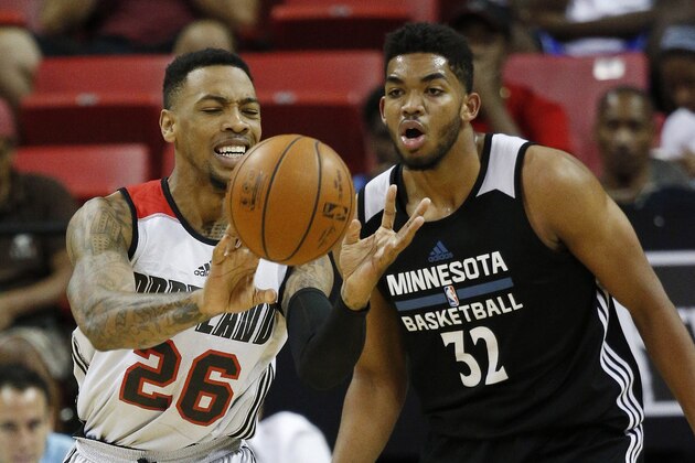 Portland Trail Blazers' Malcolm Thomas passes around Minnesota Timberwolves’ Karl-Anthony Towns during the first half of an NBA summer league basketball game Wednesday, July 15, 2015, in Las Vegas. (AP Photo/John Locher)