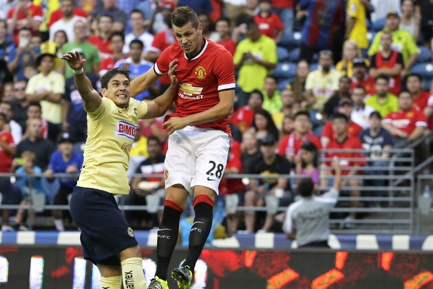 Manchester United's Morgan Schneiderlin (28) heads in a goal past Club America's Javier Guemez, left, in the first half of an international friendly soccer match, Friday, July 17, 2015, in Seattle. (AP Photo/Ted S. Warren)