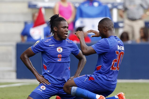 Haiti's Kervens Belfort (9) is congratulated by Duckens Nazon (20) after a goal against Honduras during the first half of a CONCACAF Gold Cup soccer match, Monday, July. 13, 2015, in Kansas City, Kan. Nazon scored off a header from Belfort. (AP Photo/Colin E. Braley)