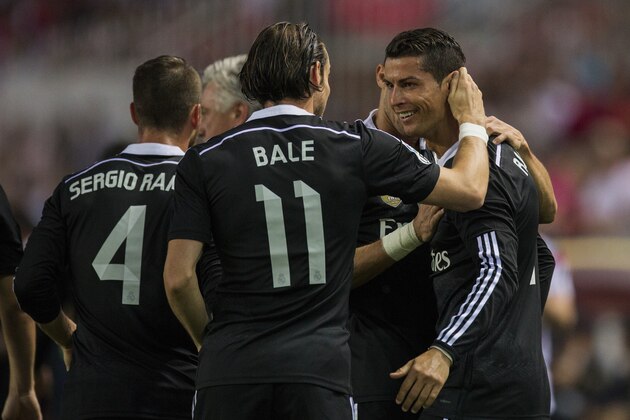 Real Madrid's Cristiano Ronaldo, right, celebrates his goal with Real Madrid's Gareth Bale, left, during a Spanish La Liga soccer match between Sevilla and Real Madrid at the Ramon Sanchez Pizjuan stadium in Sevilla, Spain, Saturday, May 2, 2015. (AP Photo/Andres Kudacki)