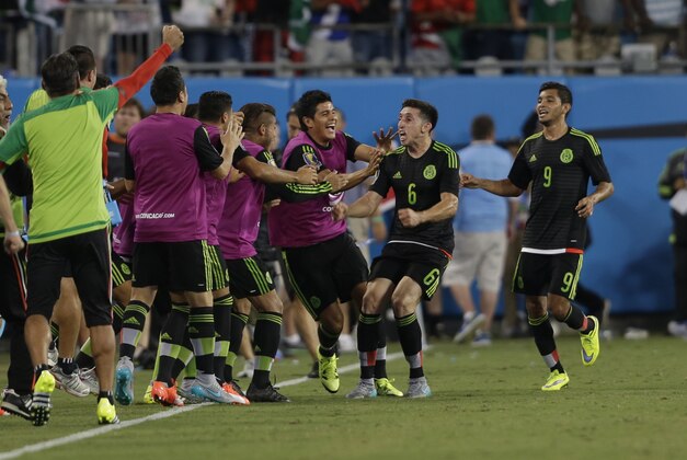 Mexico's Hector Herrera (6) celebrates with teammates after scoring a goal against Trinidad & Tobago during the second half of a CONCACAF Gold Cup soccer match in Charlotte, N.C., Wednesday, July 15, 2015. The match ended in a 4-4 draw. (AP Photo/Gerry Broome) Mexico's Hector Herrera (6) celebrates with teammates after scoring a goal against Trinidad & Tobago during the second half of a CONCACAF Gold Cup soccer match in Charlotte, N.C., Wednesday, July 15, 2015. The match ended in a 4-4 draw. (AP Photo/Gerry Broome)