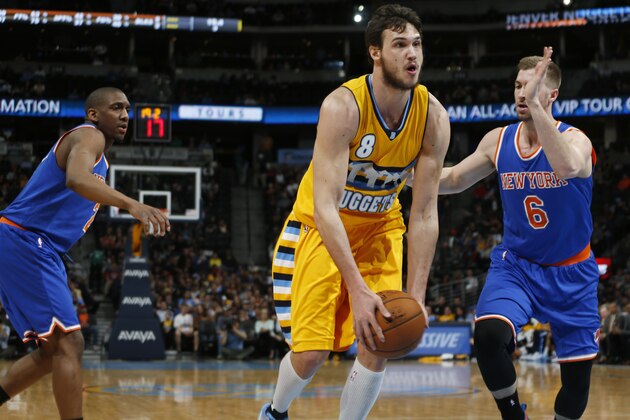 Denver Nuggets forward Danilo Gallinari, center, of Italy, drives the lane for a shot past New York Knicks guard Langston Galloway, left, and forward Travis Wear in the third quarter of an NBA basketball game Monday, March 9, 2015, in Denver. The Nuggets won 106-78. (AP Photo/David Zalubowski)