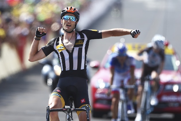 Britain's Stephen Cummings, wearing an orange helmet to mark Nelson Mandela's birthday, celebrates a she crosses the finish line to win the fourteenth stage of the Tour de France cycling race over 178.5 kilometers (110.9 miles) with start in Rodez and finish in Mende, France, Saturday, July 18, 2015. (AP Photo/Peter Dejong)