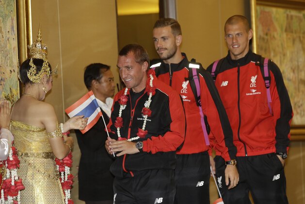 Liverpool's manager Brendan Rodgers, left, Jordan Henderson, center,  and Martin Skrtel, right, arrive at  Suvarnabhumi airport, in Bangkok, Thailand Monday, July 13, 2015. The English Premier League's team is in Bangkok to play against the Thailand All Star  team on July 14. (AP Photo/Sakchai Lalit)