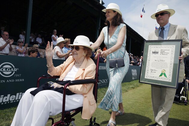 Nancy Jeffett, left, waves to the crowd as she is wheeled by Pam Shriver, center, after being inducted into the International Tennis Hall of Fame in Newport, R.I., Saturday, July 18, 2015. (AP Photo/Michael Dwyer)
