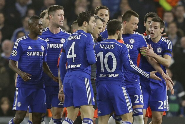 Chelsea players remonstrate with referee Bjorn Kuipers just before he showed a red card to PSG's Zlatan Ibrahimovic during the Champions League round of 16 second leg soccer match between Chelsea and Paris Saint Germain at Stamford Bridge stadium in London, Wednesday, March 11, 2015. (AP Photo/Matt Dunham)