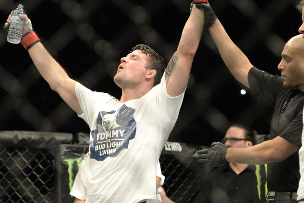 Apr 25, 2015; Montreal, Quebec, CAN; Michael Bisping (red) has his hand raised after defeating CB Dalloway (blue) during their middleweight bout during UFC 186 at Bell Centre. Mandatory Credit: Eric Bolte-USA TODAY Sports