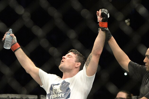 Apr 25, 2015; Montreal, Quebec, CAN; Michael Bisping (red) has his hand raised after defeating CB Dalloway (blue) during their middleweight bout during UFC 186 at Bell Centre. Mandatory Credit: Eric Bolte-USA TODAY Sports