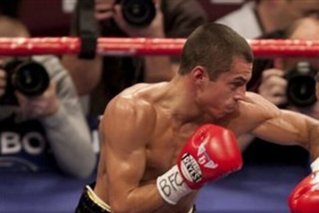 Scott Quigg, left, aims a punch at Rendall Munroe on his way to winning their super-bantamweight fight at the Manchester Evening News Arena, Manchester, England, Saturday Nov. 24, 2012. (AP Photo/Jon Super)