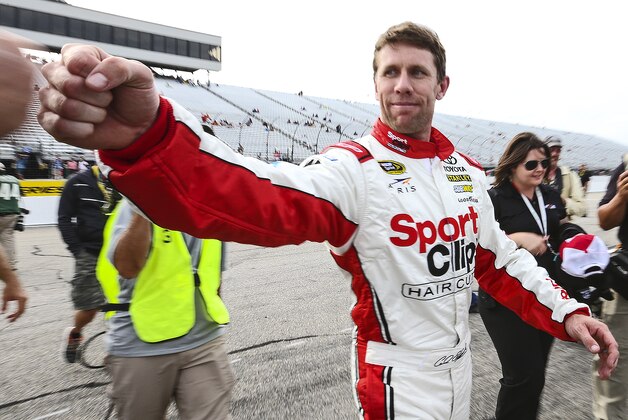 Carl Edwards fist-bumps after winning the pole position qualifying for Sunday's NASCAR Sprint Cup series auto race at New Hampshire Motor Speedway in Loudon, N.H., Friday, July 17, 2015. (AP Photo/Cheryl Senter)