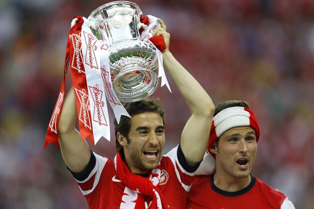 Arsenal's Mathieu Flamini, left, and Olivier Giroud, right, and  celebrates after winning the English FA Cup final soccer match between Arsenal and Hull City at Wembley Stadium in London, Saturday, May 17, 2014. Arsenal won 3-2 after extra-time. (AP Photo/Kirsty Wigglesworth)