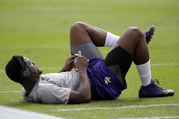 Minnesota Vikings cornerback Xavier Rhodes (29) stretches on the field as he listens to music with his Bose headphones before an NFL football game against the Miami Dolphins, Sunday, Dec. 21, 2014, in Miami Gardens, Fla. (AP Photo/Lynne Sladky)
