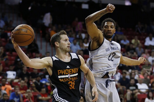 Phoenix Suns’ Mickey McConnell passes around New Orleans Pelicans’ Khem Birch during the second half of an NBA summer league basketball game Sunday, July 19, 2015, in Las Vegas. (AP Photo/John Locher)