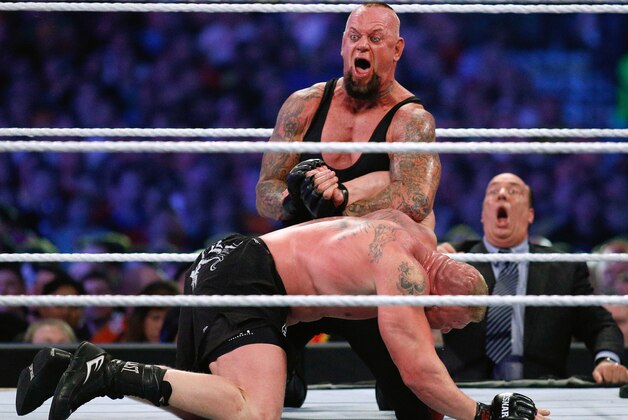IMAGE DISTRIBUTED FOR WWE - The Undertaker, top, and Brock Lesnar wrestle during Wrestlemania XXX at the Mercedes-Benz Super Dome in New Orleans on Sunday, April 6, 2014. (Jonathan Bachman/AP Images for WWE)